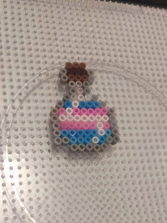 A trans pride potion perler charm!